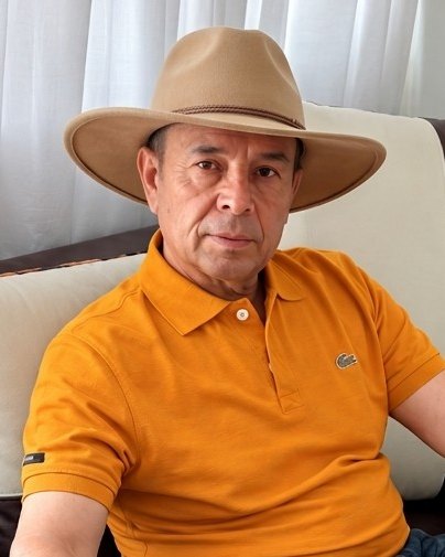 Cliente con sombrero beige y camisa naranja, sentado en un sillón